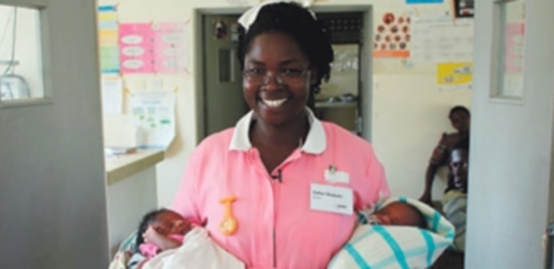 .Comadrona africana con dos mellizos recien nacidos después de haber ayudado a su madre en el parto. / El Adelantado