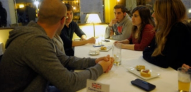 Un grupo de alumnos españoles y extranjeros conversan en inglés en el restaurante Casares. / Kamarero