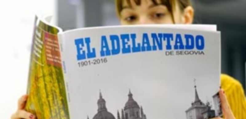 Una joven lectora ojea el número especial editado con motivo del 115 aniversario de El Adelantado de Segovia. / Kamarero