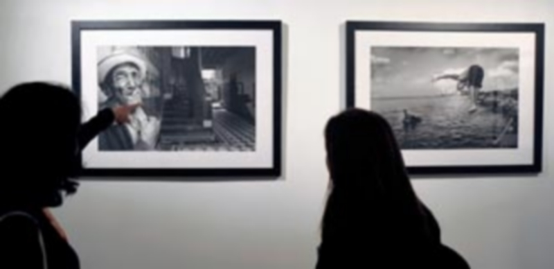 Dos mujeres contemplan las fotografías de la colección ‘Habana’ del artista visual Robés