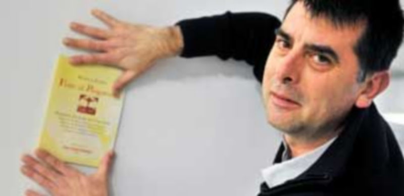 Luis Besa sostiene uno de los ejemplares del libro que cuenta el fantástico relato de Perellós en el purgatorio de San Patricio. / Kamarero