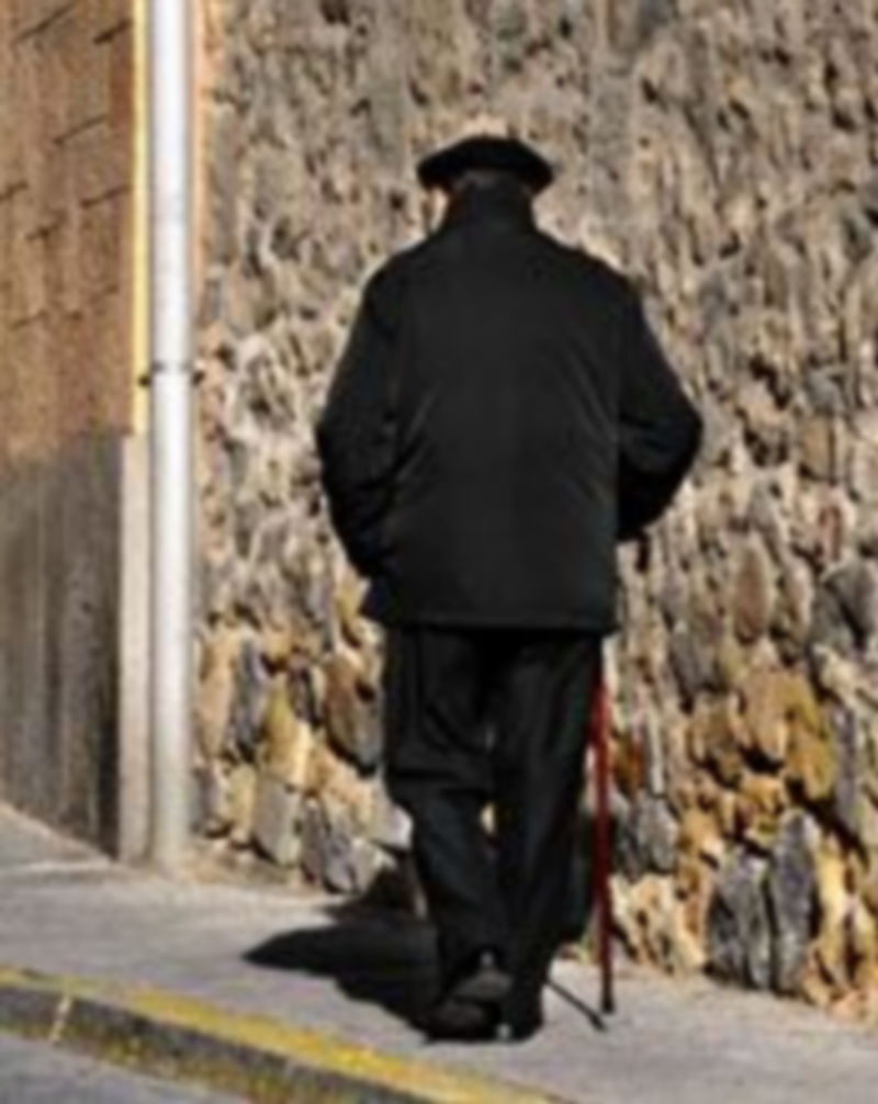 Un anciano camina por una calle de Segovia