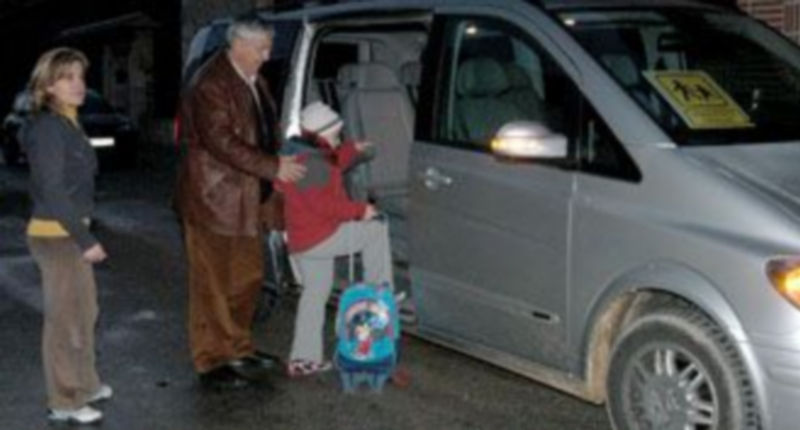 María del Mar despide a su hijo que viaja cada mañana con el taxista Carlos Sanza que años atrás también ha transportado a sus hijos mayores./Guillermo Herrero