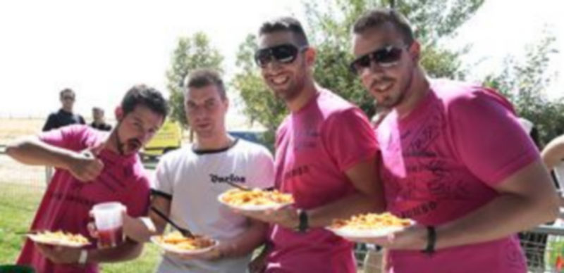 Dos vecinos del barrio sirviendo platos para los asistentes a la macarronada en la alamedilla del barrio. / l.Mazagatos
