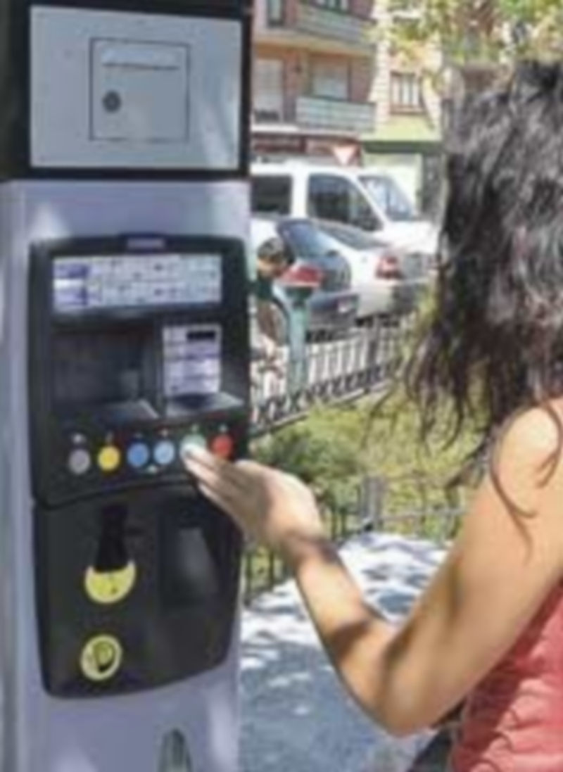 Una joven conductora adquiere su tique en el parquímetro de la plaza Alto de los Leones de Castilla. / Alberto Benavente