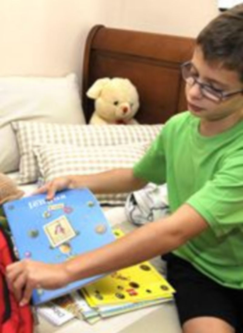 Un niño metiendo sus libros escolares en la mochila. / Alberto Benavente