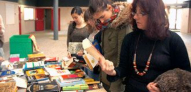 Publico ante el expositor de venta y recogida de libros de AIDA en el campus./ VICTORIA MONFER