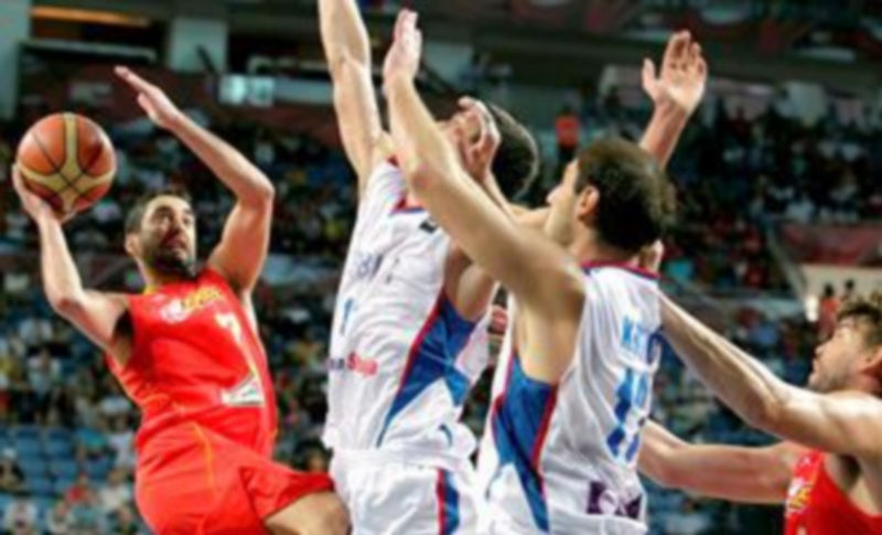 El escolta de la selección de española de baloncesto Juan Carlos Navarro (i) intenta un lanzamiento a canasta frente a los jugadores de la selección serbia./ EFE