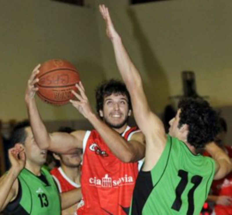 El segoviano Calvente entra a canasta ante la defensa del palentino Inclán. / Juan Martín.