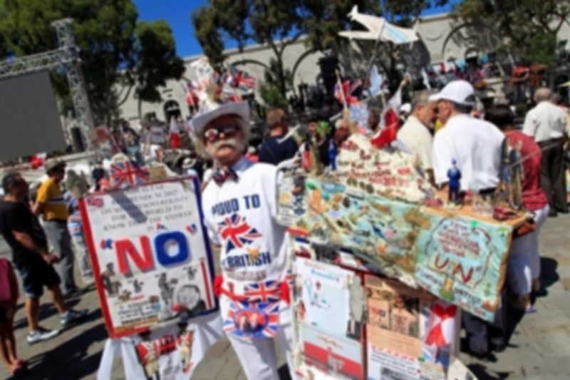 Un hombre con un traje colorido decorado con banderas durante la campaña.