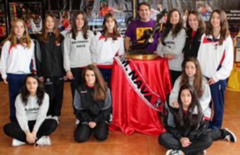 El equipo cadete femenino del Club Balonmano Nava posa junto al trofeo de campeones del mundo de la Selección Española. / BM NAVa
