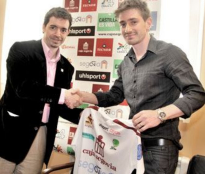 Luis Sanz y Geison se estrechan la mano durante la presentación del jugador en la sede del Caja Segovia./ KAMARERO