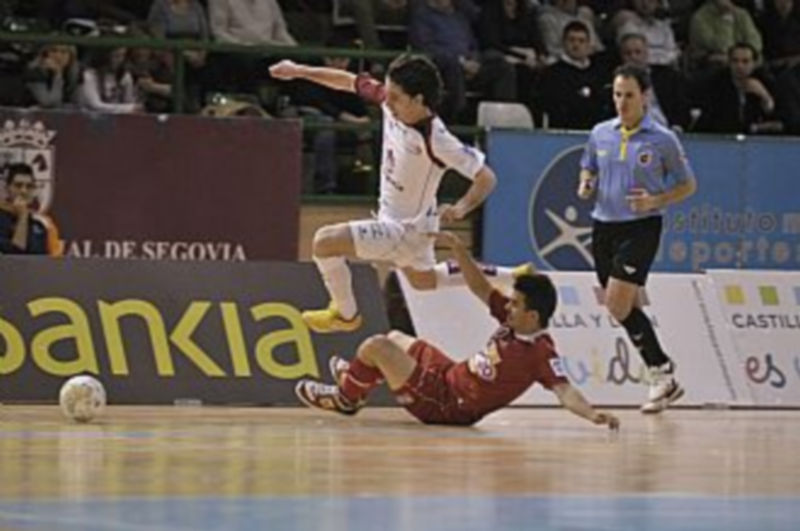 Murga recibe la entrada de Alex ante la mirada de uno de los colegiados en un momento de la primera parte del encuentro jugado en el pabellón Pedro Delgado. / Juan Martín