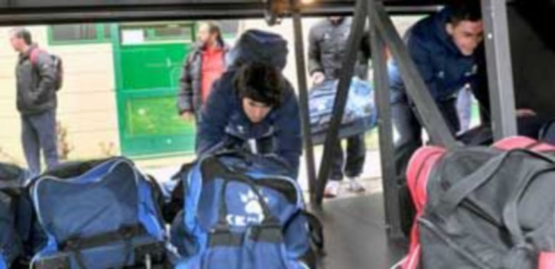 Murga y Antoñito colocan sus bolsas de viaje en el maletero del autobús que condujo ayer a la plantilla del Caja Segovia a Alcalá de Henares