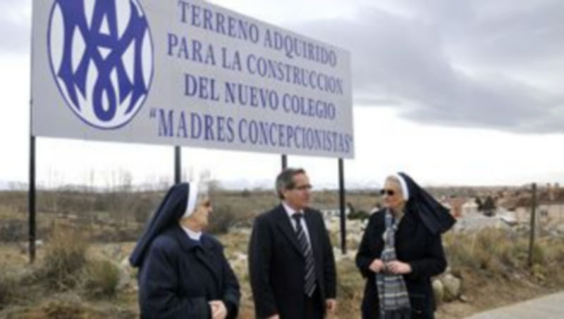Las religiosas con el alcalde de La Lastrilla ante el cartel que identifica la ubicación del futuro colegio./JUAN MARTÍN