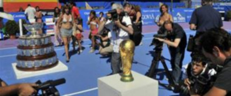 Un gran número de periodistas toman imágenes de la Copa del Mundo de fútbol y la ensaladera de la Copa Davis./ JUAN MARTÍN