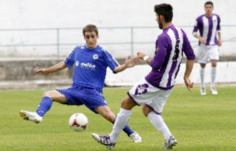 Un jugador cuellarano intenta cortar el avance de un balón golpeado por un rival del Real Valladolid B. / Gabriel Gómez