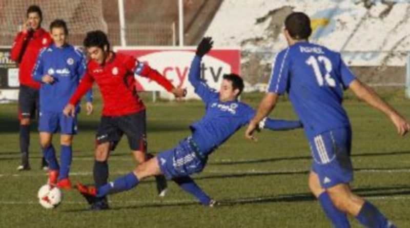 Un jugador del Cuéllar estira la pierna para intentar quitarle la pelota a un rival abulense. / David Castro