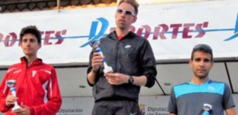 Los tres primeros de categoría masculina recogen sus trofeos en el pódium. / Kamarero