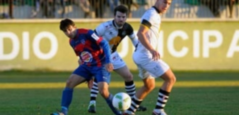 El atacante de la Gimnástica Segoviana Quino ejecuta unpase ante la presión de dos rivales del Unionistas. / KAMARERO