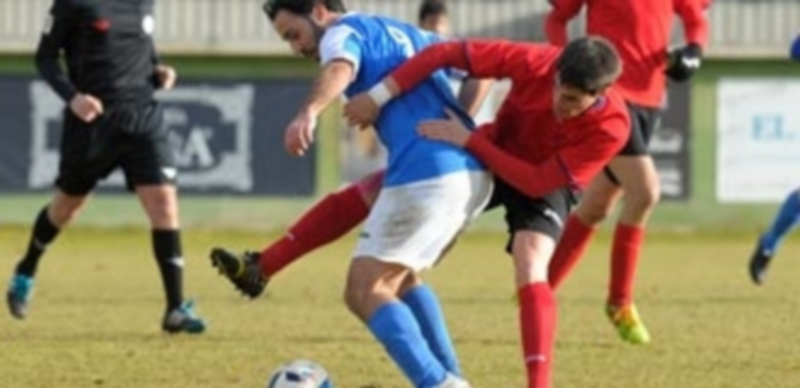 El defensa central del CD La Granja Quique trata de robarle el balón al 9 del Unami CP