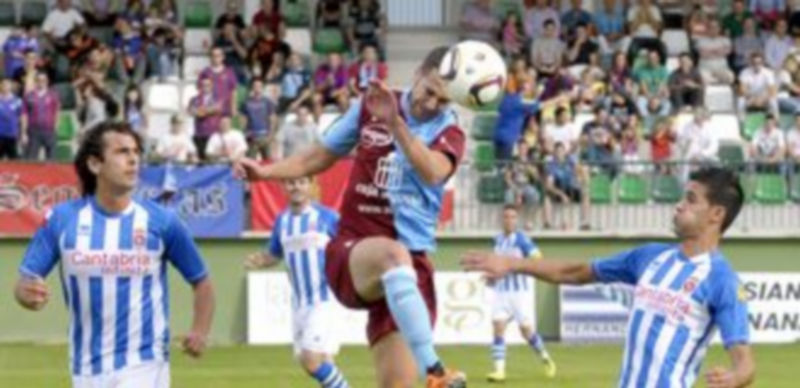 Fran Dorado cabecea una pelota en presencia de dos contrarios durante la primera parte del encuentro que jugaron en La Albuera Segoviana y Gimnástica de Torrelavega. / Alberto Benavente