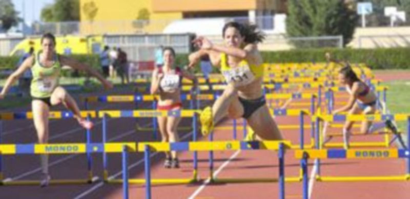 Un momento de la prueba femenina de los 100 metros vallas con una de las participantes a punto de caer./ Alberto Benavente