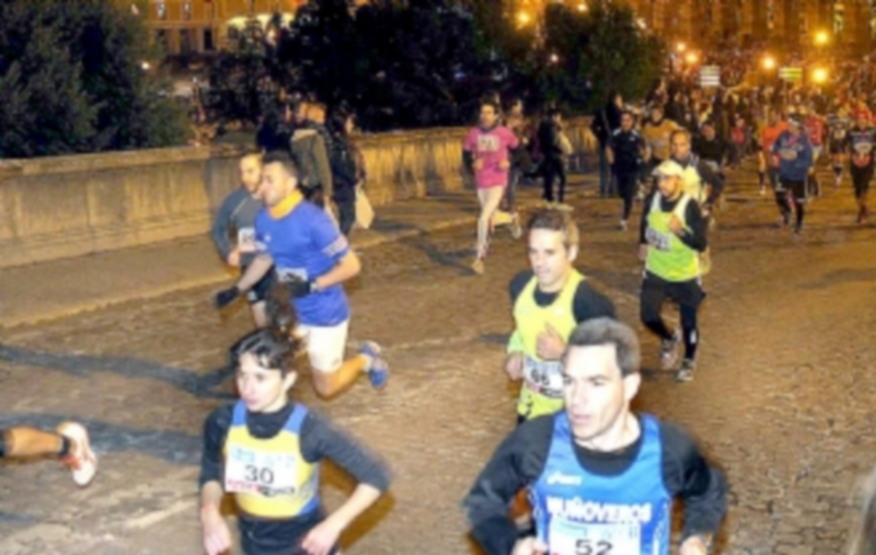 Momento de la carrera de fin de año con los corredores subiend con el Acueducto de fondo. / KAMARERO