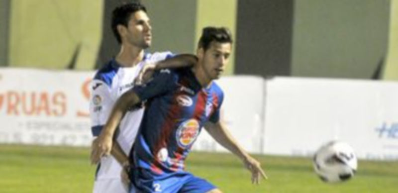 El gimnástico Roberto intenta robar el balón ante la presencia de un rival durante una jugada de la primera parte. / Alberto Benavente