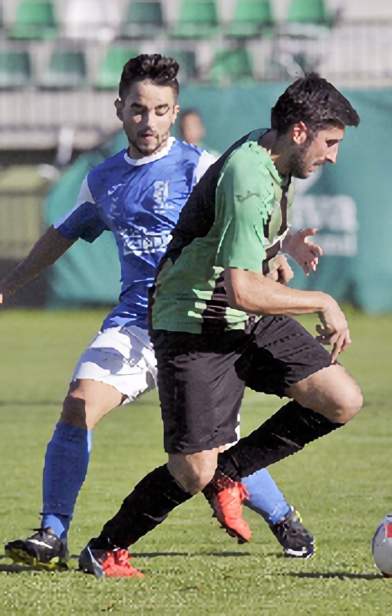 Movimientos en el liderato 12 El jugador de El Espinar San Rafael Teo conduce un balón ante la presión del centrocampista del Unami Guti. / KAMARERO