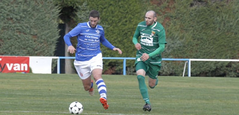 El mediapunta del CD La Granja Mario Zúñiga conduce un balón ante la presión de un rival del Atlético Palencia. / NEREA LLORENTE
