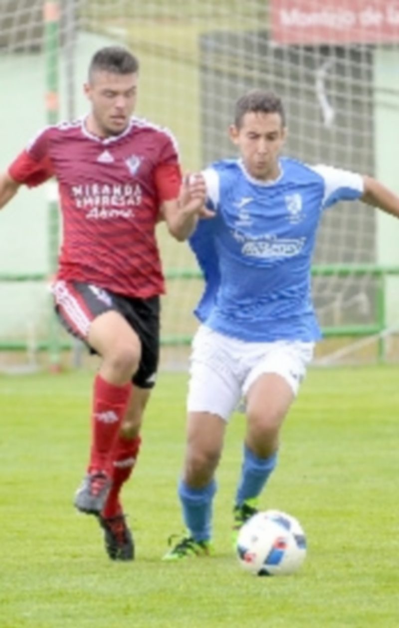 Leña por el liderato 18 El atacante del Unami CP Ibra conduce un balón en velocidad ante la presión de un rival de CD Mirandés B. / KAMARERO