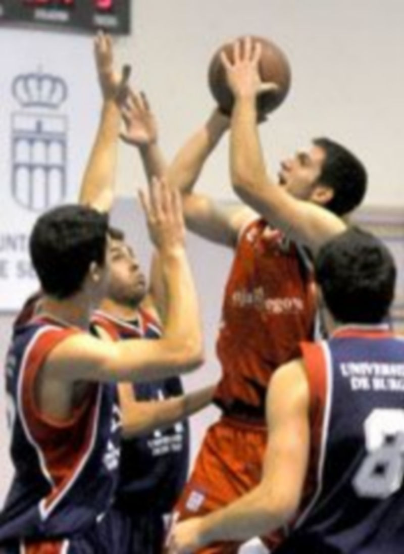 Jorge González se eleva hacia la canasta ante dos jugadores del UBU. / A. Benavente