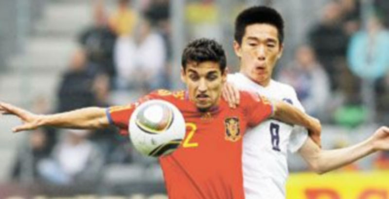 Navas mantiene el control del esférico ante la presión del coreano Lee Jung Soo. / D. Ebenbichler (Reuters)