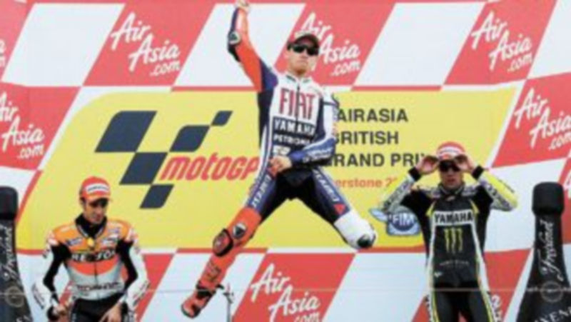 Jorge Lorenzo celebra su victoria en el podio del trazado inglés