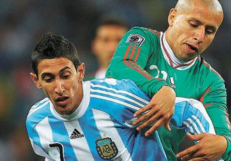 El argentino Ángel di María lucha por el balón con el mexicano Bautista. / S. Suki (EFE)