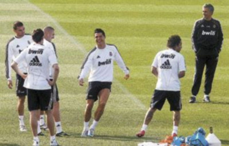 Cristiano Ronaldo bromea con sus compañeros bajo la atenta mirada de José Mourinho durante la sesión de entrenamiento de ayer en Valdebebas. / Efe