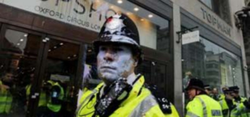 Policias son atacados con balas de pintura de colores frente a una tienda de la cadena Topshop