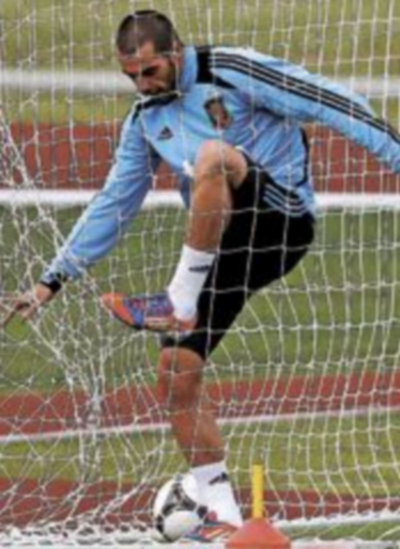 Negredo trata de zafarse de la red de una de las porterías durante el entrenamiento de la selección. / Reuters
