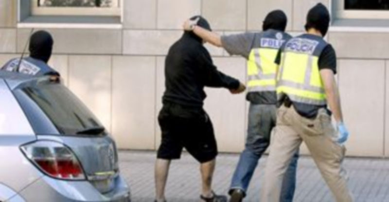 Agentes de la Policía Nacional conducen a uno de los detenidos hoy en un polígono industrial de Usurbil (Guipúzcoa)