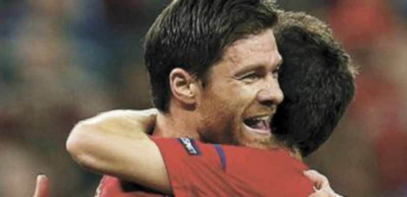 Xabi Alonso recibe el abrazo de Cesc Fábregas tras marcar el primer gol ante Francia.  / Reuters