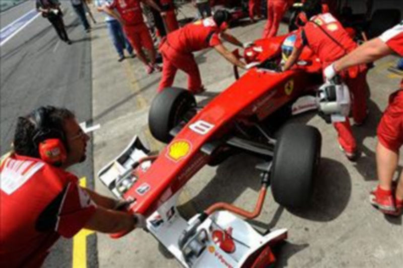 Técnicos de la escudería Ferrari preparan el auto del piloto español Fernando Alonso. / EFE