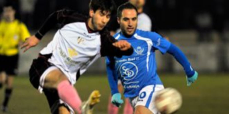 Un jugador burgalés golpea el balón ante la presencia del granjeño Iván. / kamarero