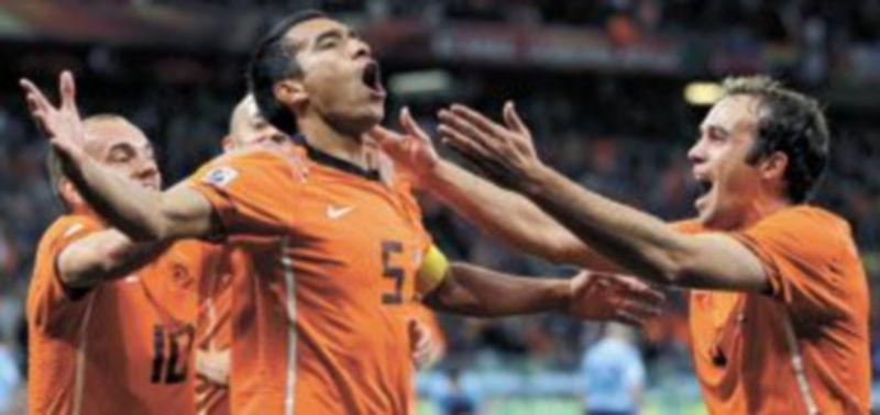 El ex barcelonista Giovanni van Bronckhorst (c) es felicitado por sus compañeros tras abrir el marcador. / OLIVER WEIKEN (Efe)