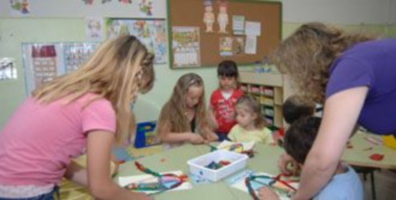 Varias profesoras atienden a un grupo de alumnos en el colegio de Hontanares de Eresma. / Alberto Benavente