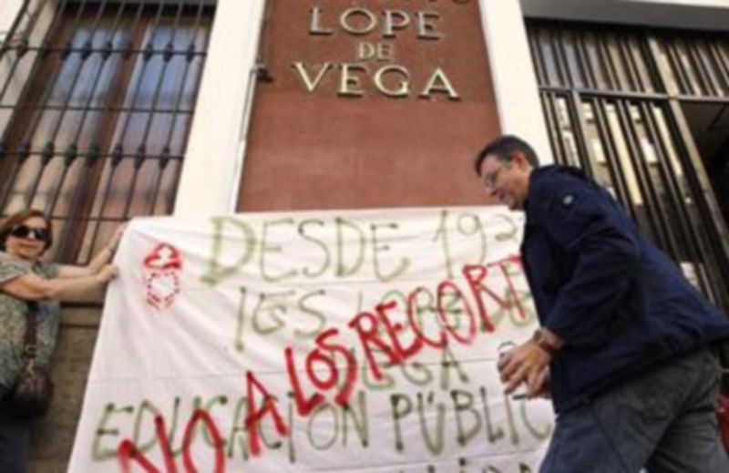 Dos profesores colocan una pancarta en la fachada del IES Lope de Vega de Madrid al inicio de la primera jornada de huelga en la enseñanza secundaria de la comunidad autónoma./EFE