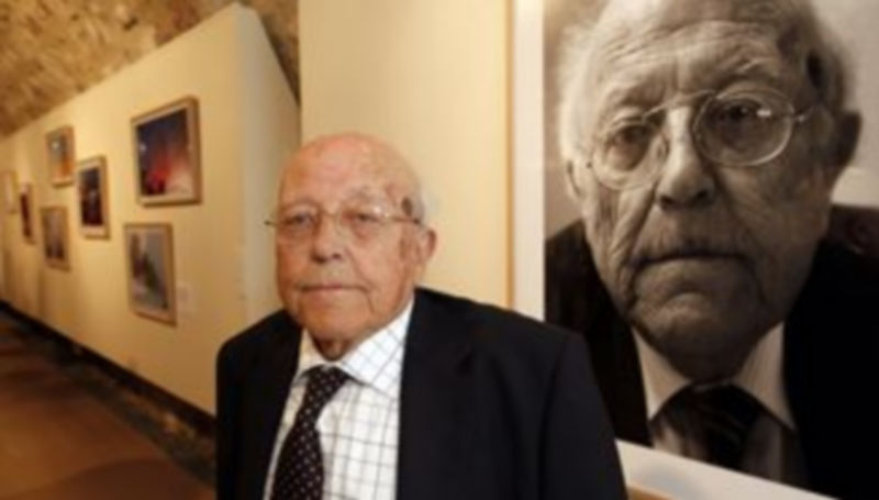 El escritor José Jiménez Lozano posa ante una de las fotografías con su imagen