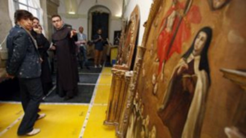 El público observa con atención los detalles de las obras de arte de la capilla