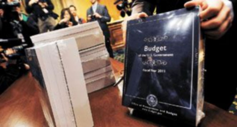 Un trabajador del Senado de EEUU coloca sobre una mesa varios ejemplares del presupuesto público para el ejercicio fiscal 2011. / Reuters