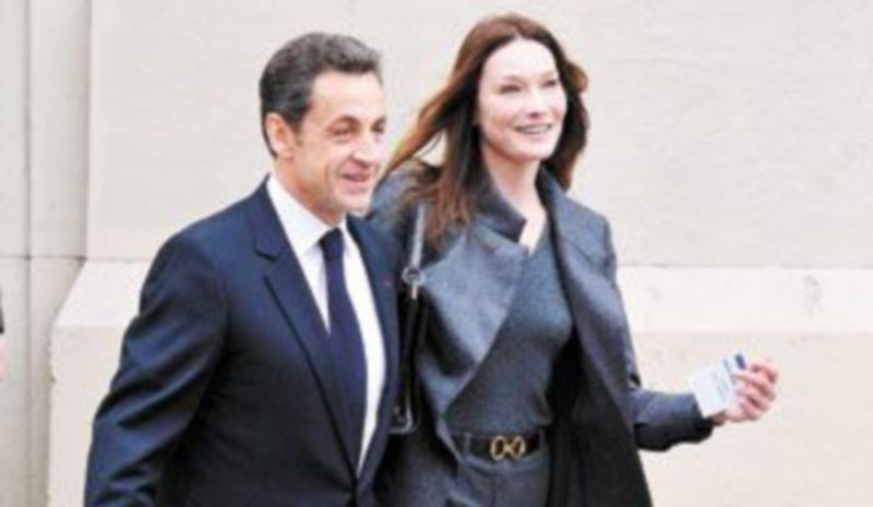Sarkozy y Carla Bruni salen del colegio electoral de París donde votaron. / Reuters